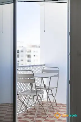 a table and a chair on a balcony at La Casa Bonita de la Victoria Livework By Cadiz Time in Cádiz