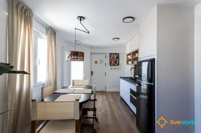 a kitchen with white cabinets and a black refrigerator at La Casa Bonita de la Victoria Livework By Cadiz Time in Cádiz