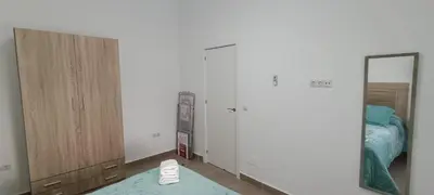a bedroom with white walls and a mirror and a bed at Apartamento El Albero in Jerez de la Frontera