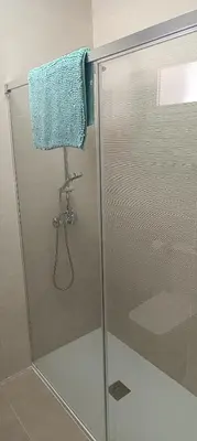 a shower with a glass door with a blue towel at Apartamento El Albero in Jerez de la Frontera