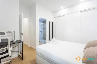 a white bedroom with a bed and a mirror at Cádiz Living by LiveWork in Cádiz