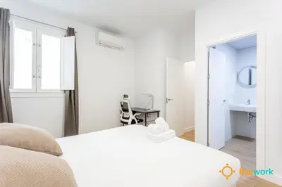 a white bedroom with a bed and a sink at Cádiz Living by LiveWork in Cádiz