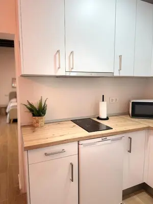 a kitchen with white cabinets and a counter top at Loft Mamalú Jerez in Jerez de la Frontera