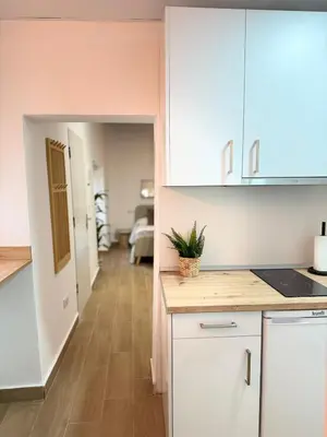 a kitchen with white cabinets and a hallway at Loft Mamalú Jerez in Jerez de la Frontera