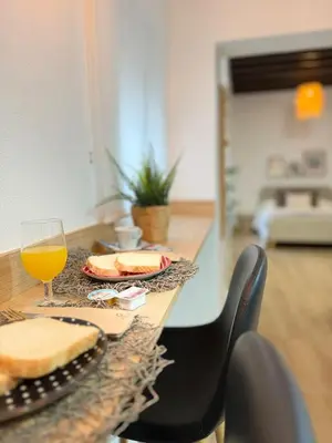 a table with a glass of orange juice and cheese at Loft Mamalú Jerez in Jerez de la Frontera