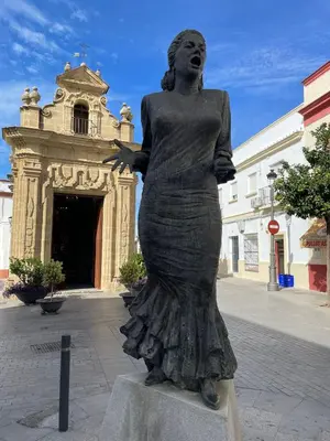 a statue of a woman standing in front of a building at Loft Mamalú Jerez in Jerez de la Frontera