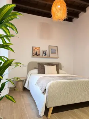 a bedroom with a bed and an orange chandelier at Loft Mamalú Jerez in Jerez de la Frontera
