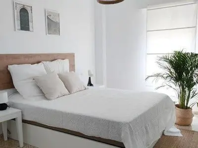 a white bedroom with a large bed with white pillows at Apartamento Residencial Arcos in Jerez de la Frontera