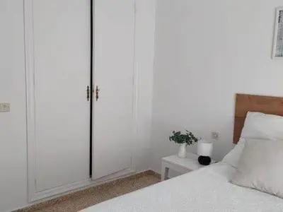 a white bedroom with a bed and a closet at Apartamento Residencial Arcos in Jerez de la Frontera