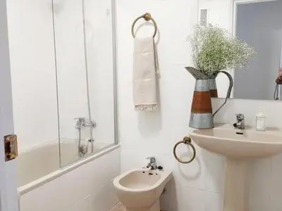 a white bathroom with a sink and a toilet at Apartamento Residencial Arcos in Jerez de la Frontera