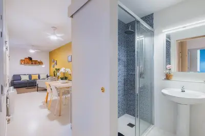 a bathroom with a sink and a glass shower at Cadizz Anda La Luz Tu lugar en El Puerto Santa María centro ciudad in El Puerto de Santa María