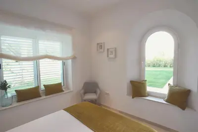 a bedroom with two windows and a bed and a chair at Villa 211 by Villamya in Vallejas