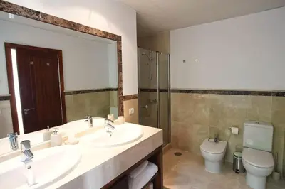 a bathroom with two sinks and a toilet and a mirror at Villa 211 by Villamya in Vallejas