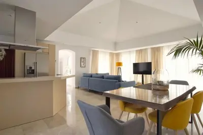 a living room with a table and yellow chairs at Villa 211 by Villamya in Vallejas