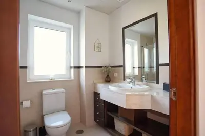 a bathroom with a toilet and a sink and a mirror at Villa 211 by Villamya in Vallejas