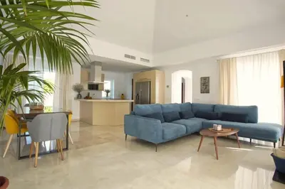 a living room with a blue couch and a table at Villa 211 by Villamya in Vallejas