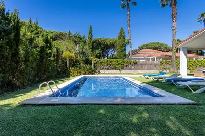 a swimming pool in a yard with palm trees at Villa el Cenador, Urb Roche Conil in Roche