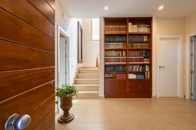 a hallway with a book shelf filled with books at Villa el Cenador, Urb Roche Conil in Roche