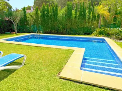 a swimming pool in the grass next to a yard at Villa el Cenador, Urb Roche Conil in Roche