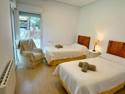 a bedroom with two beds and a window at Villa el Cenador, Urb Roche Conil in Roche