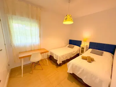 a room with two beds and a table and a desk at Villa el Cenador, Urb Roche Conil in Roche