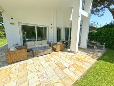 a patio with a couch and chairs on a house at Villa el Cenador, Urb Roche Conil in Roche