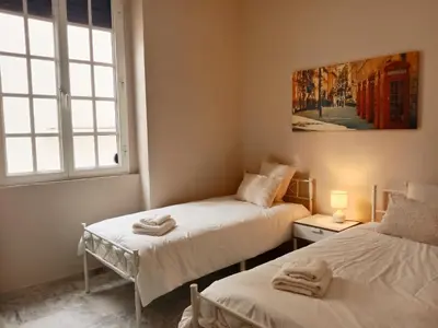 two twin beds in a room with a window at Casa Remedios in Jerez de la Frontera
