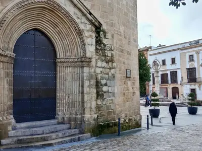 a person walking past a large door on a building at Casa Remedios in Jerez de la Frontera