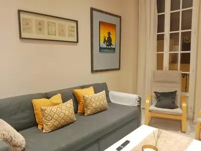 a living room with a gray couch with yellow pillows at Casa Remedios in Jerez de la Frontera