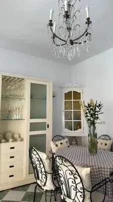 a dining room with a table with chairs and a chandelier at Casa Michel in Chipiona
