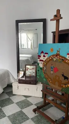 a room with a painting on a easel and a mirror at Casa Michel in Chipiona