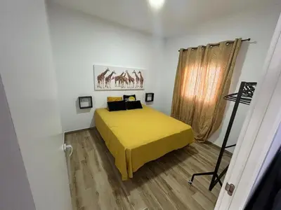 a bedroom with a yellow bed and a window at casa comoda sanluca in Monte Olivete