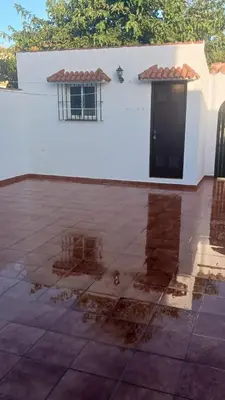 a white building with a black door and a window at casa andaluza 109 in Novo Sancti Petri