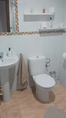 a white bathroom with a toilet and a sink at casa andaluza 109 in Novo Sancti Petri