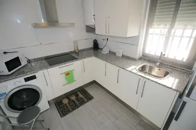 a kitchen with a sink and a washing machine at Buleria in Jerez de la Frontera