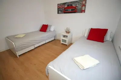a room with two beds and a table with a bedskirts at Buleria in Jerez de la Frontera