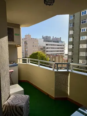 a balcony with green flooring on a building at Grand Beachfront Apartament - Cadiz in Cádiz
