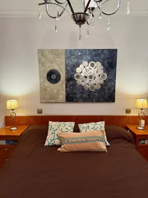 a bedroom with a bed and a painting on the wall at Grand Beachfront Apartament - Cadiz in Cádiz