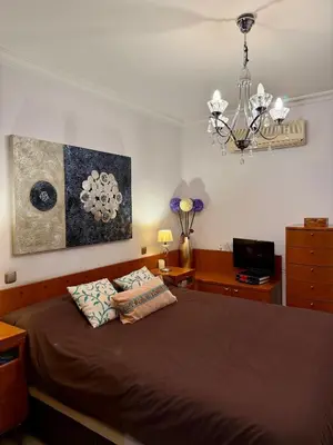 a bedroom with a bed and a chandelier at Grand Beachfront Apartament - Cadiz in Cádiz