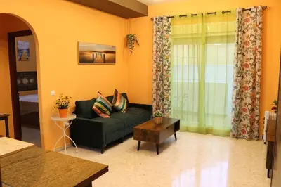a living room with a green couch and a table at Apartamento La Venencia II in Jerez de la Frontera
