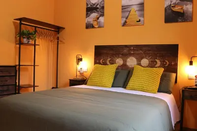 a bedroom with a large bed with two yellow pillows at Apartamento La Venencia II in Jerez de la Frontera