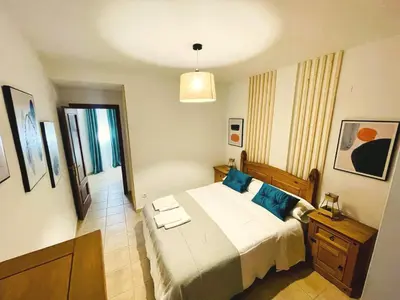 a bedroom with a large bed with blue pillows at Loft 41 en Algar by Villamya in Algar
