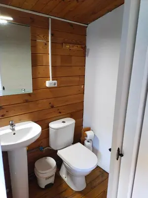 a bathroom with a white toilet and a sink at Cabañas de Veròn in Conil de la Frontera