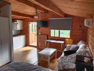 a living room with a couch and a table in a cabin at Cabañas de Veròn in Conil de la Frontera