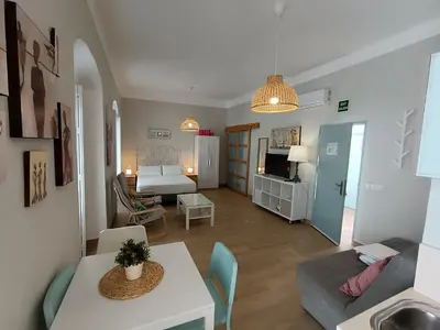 a small living room with a couch and a table at Apartamentos turísticos CASA de los BALCONES in Chipiona