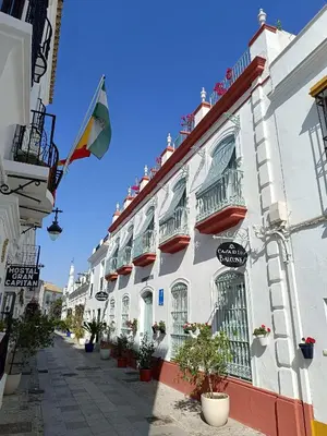 a group of lawn chairs and an umbrella on a roof at Apartamentos turísticos CASA de los BALCONES in Chipiona
