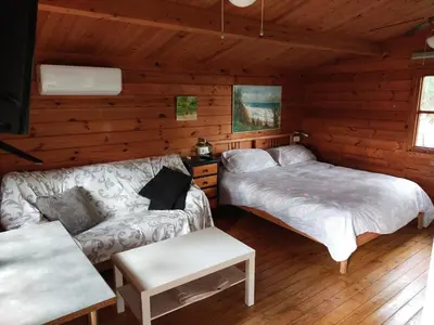 a room with two beds and a couch in a cabin at Cabañas de Veròn in Conil de la Frontera