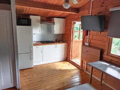 a kitchen with white appliances in a wooden cabin at Cabañas de Veròn in Conil de la Frontera