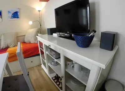 a living room with a tv on a white table at DescubreHome Sacramento in Cádiz
