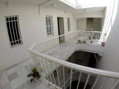 a white staircase in a white building with a window at DescubreHome Sacramento in Cádiz